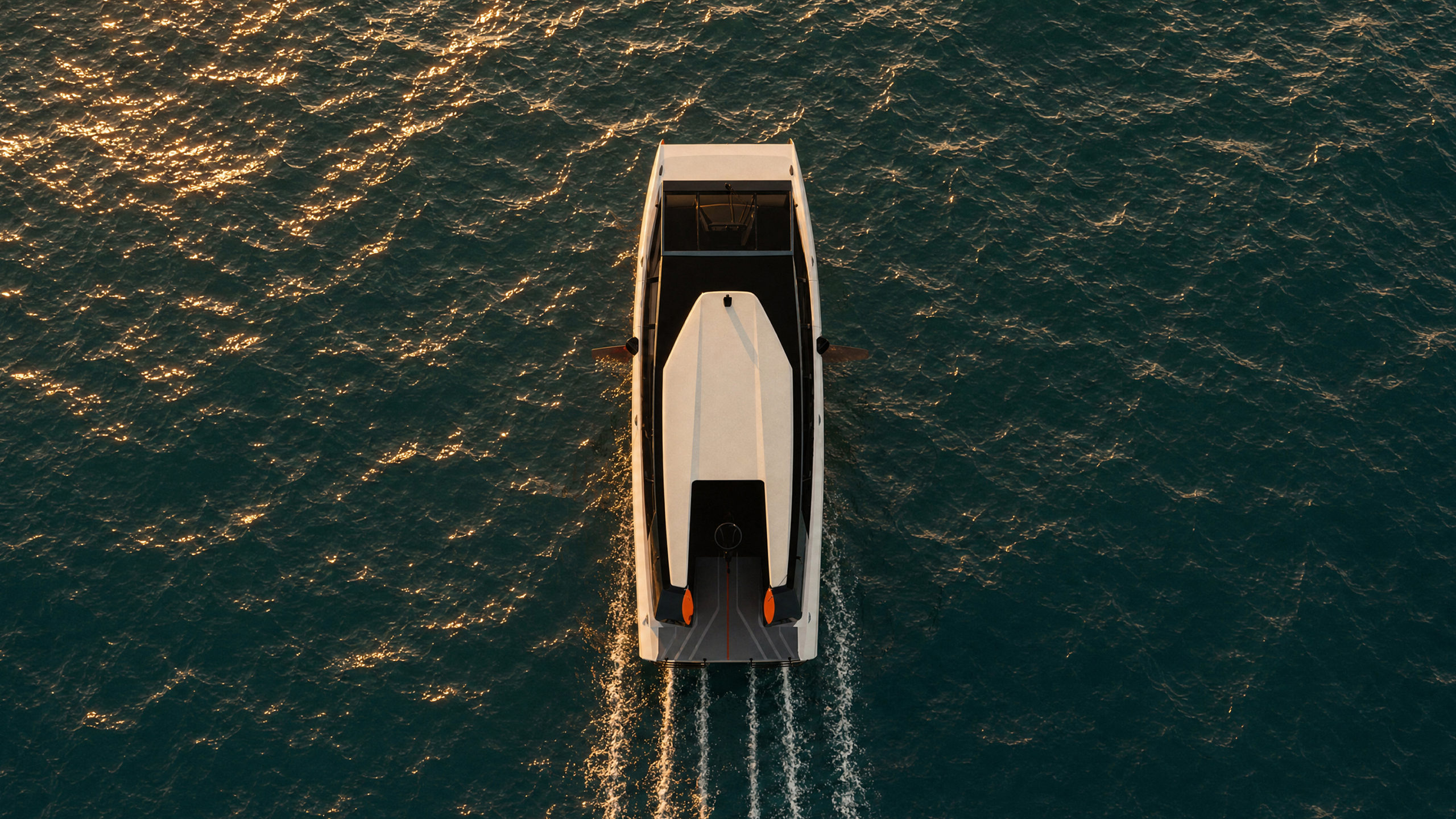 MobyFly MBFY-S 3D Render (aerial top-down view) 3D render of the MobyFly MBFY-S zero-emission hydrofoil boat seen from directly above, foiling across open water at golden hour. The hull travels with minimal wake—only narrow trails from the foil struts disturb the surface, leaving the surrounding water largely undisturbed. White hull with orange foil strut tips visible beneath the stern.